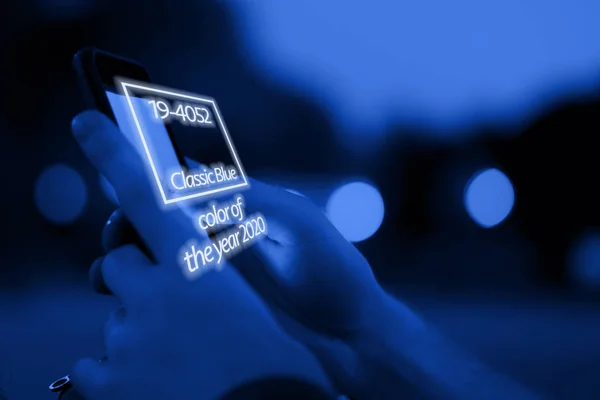 Close up osoba ruce drží telefon a čtení elektronické knihy, barva roku 2020 trend, klasický modrý tón — Stock fotografie