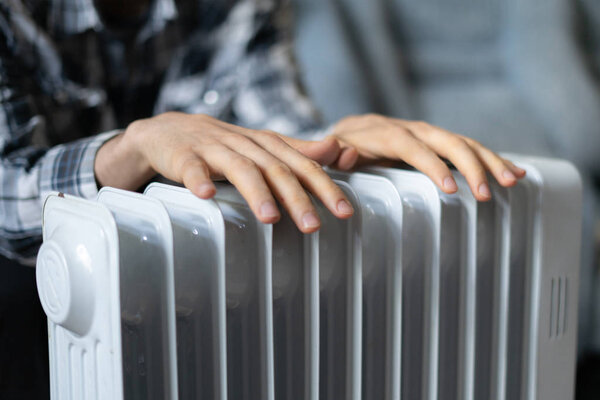 feeling cold, getting warm, hands touching the heater close up
