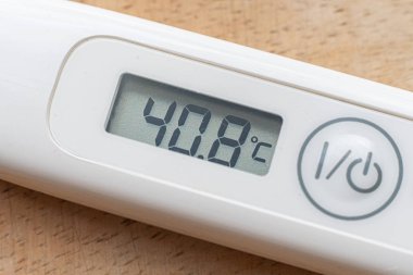 Termometrenin makro görüntüsü yüksek sıcaklığı ve hastalık konseptini gösteriyor.