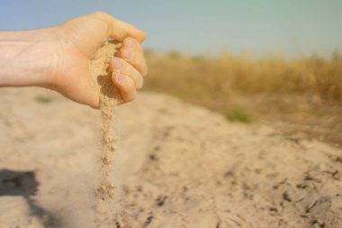 Hayal kırıklığının ve üzüntünün sembolü olarak kumları kumlara döken el.