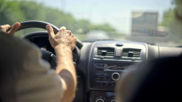 Primer plano silueta del hombre que conduce un coche en una puesta de sol durante la hora dorada — Vídeos de Stock