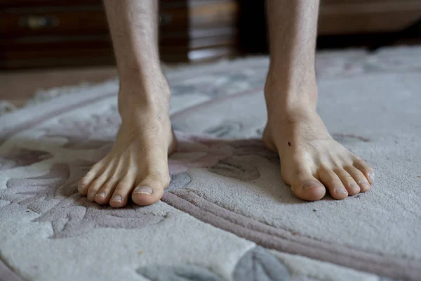 the bare feet at home on the carpet on the floor, wake up early in the morning