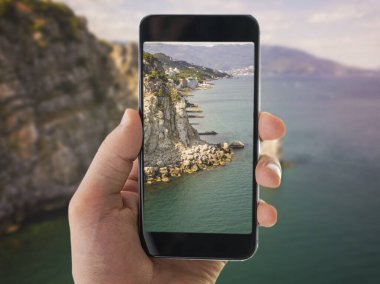 El ele tutuşan akıllı telefon ve manzara fotoğrafçılığı.