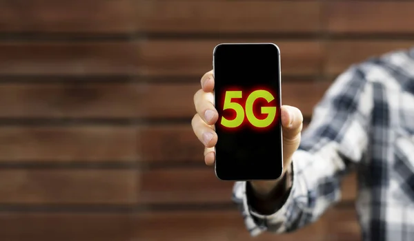 Un teléfono con un texto de conexión de 5g en él, concepto de red de próxima generación rápida — Foto de Stock