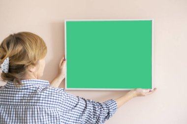 a person put the empty frame for family photo on the wall at home in the room on the wall, simple mock up design