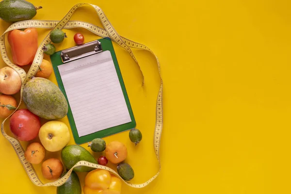 a flat lay of the blank paper sheet mockup for the diet plat recipe, raw fresh fruit on table