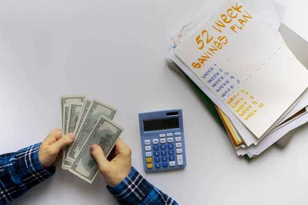 Um plano de poupança de 52 semanas, pessoa contar dinheiro e calcular o rendimento futuro — Fotografia de Stock