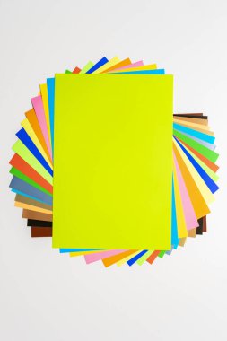 a stack of of color paper sheets on the table flat lay, view from above