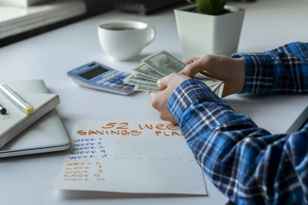 Un plan de ahorro de 52 semanas, persona contar dinero y calcular los ingresos futuros — Foto de Stock
