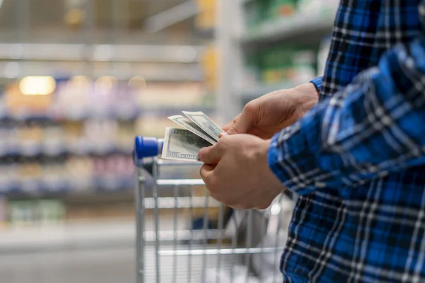 A person in a grocery store, hands count the money currency — ストック写真