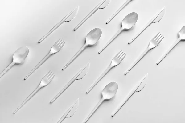 Disposición plana creativa de tenedores de plástico cucharas y cuchillos patrón —  Fotos de Stock