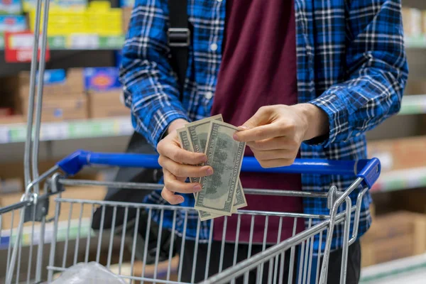 A person in a grocery store, hands count the money currency — ストック写真