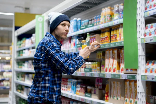 Cleptomanía concepto, un hombre en la tienda de comestibles robar comida y ponerlo en el bolsillo —  Fotos de Stock