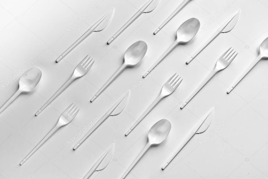 creative flat lay of plastic forks spoons and knifes pattern