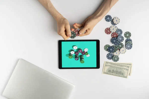 Una persona de arriba jugando los juegos de azar en línea en casa y ganar el dinero, la pila de fichas en la pantalla del gadget — Foto de Stock