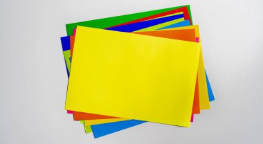 a stack of of color paper sheets on the table flat lay, view from above