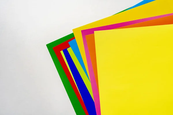 A stack of of color paper sheets on the table flat lay, view from above — 스톡 사진