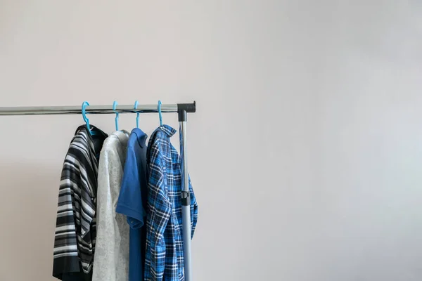 Simple wardrobe hanger of casual clothes at home, simple isolated against the wall — 图库照片