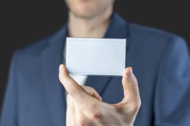 İş adamı elinde boş bir rozet tutuyor. Kopya alanı modeli, yetki ve kimlik bilgileri var.