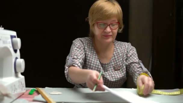 Женщин портной работы в мастерской на темном столе — стоковое видео