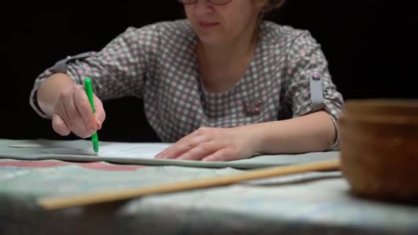 Vrouw op maatwerk in workshop op de donkere tafel — Stockvideo