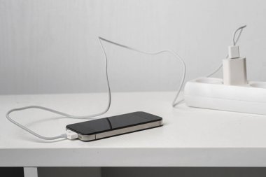 Telefon kablosu olan bir soket beyaz rafta hızlı şarj aleti.