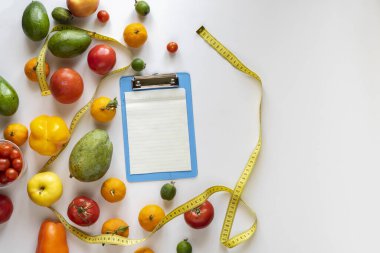 Diyet tabağı tarifi için boş kağıt maketinin düz uzantısı, masada çiğ taze meyve.