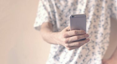 Akıllı telefon kullanarak duvarın yanında dikilen sıradan bir hippi. Sosyal sorunlar, sosyal kişisel sorunlar