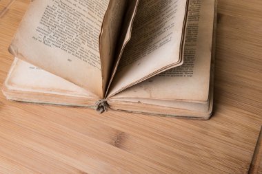 Gözlüklü ahşap bir masa üzerine eski kitap açık