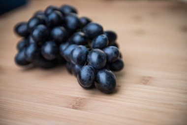 Kara üzüm ve ahşap arka plan üzerinde avokado