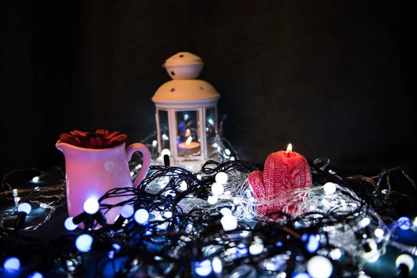 Uma vela vermelha com luzes de Natal na luz atmosférica — Fotografia de Stock