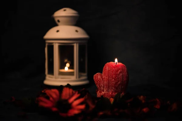 Natureza morta num fundo escuro. Decoração de velas e castiçais, com margaridas e folhas vermelhas. Foco seletivo . — Fotografia de Stock