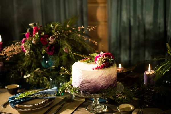 Beautiful purple cake with streaks of white cream and decorated with berries BlackBerry, blueberry and cherry. Over blue wooden table. Dark rustic style. — Stock Photo, Image
