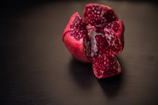 Fresh ripe pomegranate on a dark wooden backgroundgarnet in the section. pomegranate — Stock Photo, Image