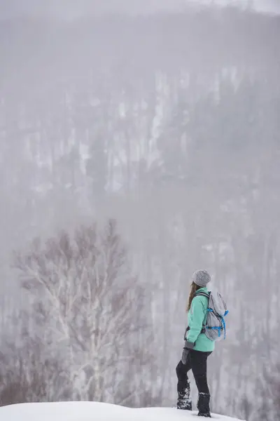 一个女人在冬季远足时停下来休息 — 图库照片