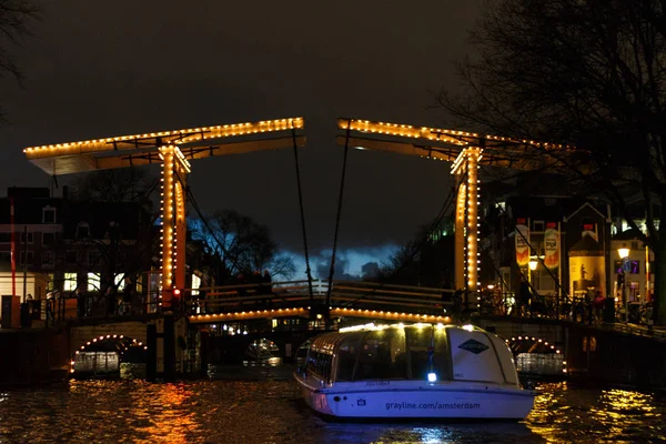 Beleuchtete Zugbrücke bei Nacht in Amsterdam — Stockfoto