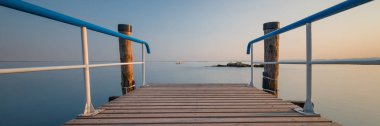 Wooden pier with blue railing clipart