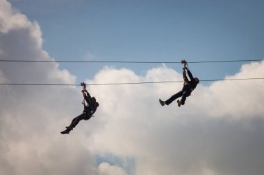 İnsanlar teleferik hattı kullanarak eğleniyor.