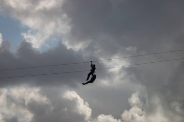 İnsanlar teleferik hattı kullanarak eğleniyor.