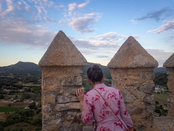 Mujer mirando a través de la muralla defensiva del castillo Sant Salvador en Arta, España — Foto de Stock