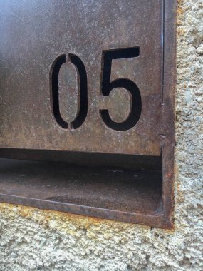 Metal kabartmalı ve duvara işlenmiş 05 numara.