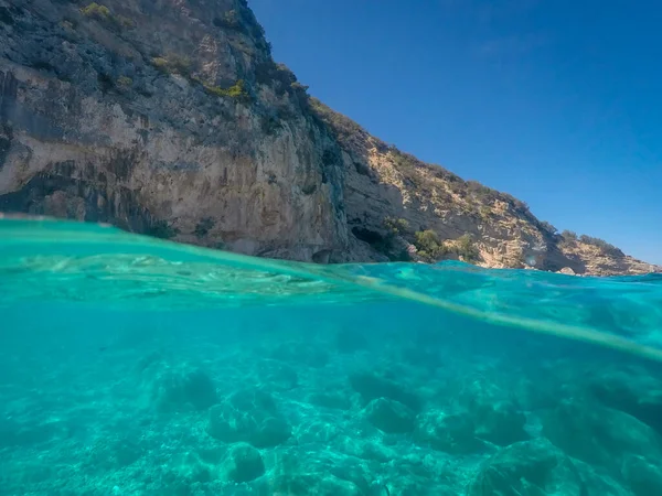 在意大利撒丁岛Cala Dei Gabbiani被水线隔开的水面 岩石和蓝天 地中海 — 图库照片