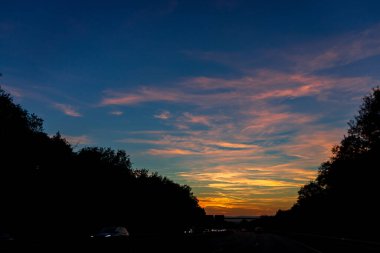 Gün batımından sonra dramatik bir gökyüzü, Alman otobanı üzerinde öğleden sonra renkli bulutlar...