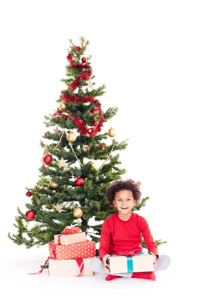 Мальчик смешанной расы возле елки — стоковое фото