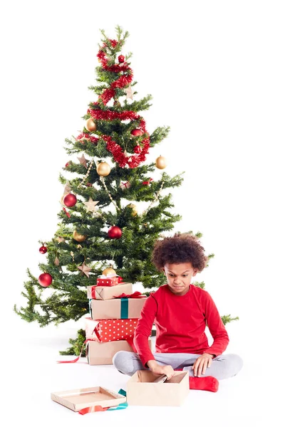 Мальчик распаковывает рождественские подарки — стоковое фото
