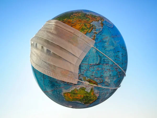 Глобус Медицинской Маске Фоне Голубого Неба — стоковое фото