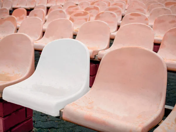 Ein Weißer Plastikstuhl Inmitten Pinkfarbener Alter Schäbiger Stühle — Stockfoto