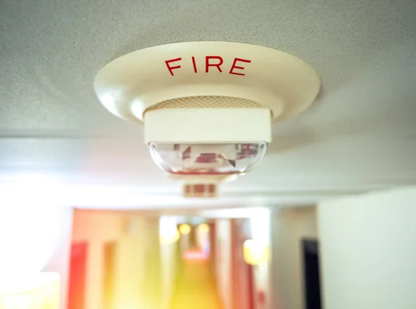 火災警報が火の間に鳴った 碑文火災と部屋の天井に設置煙センサー — ストック写真