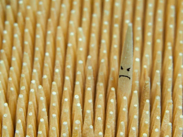 Un palillo con un emoji malvado es más alto que muchos otros. — Foto de Stock