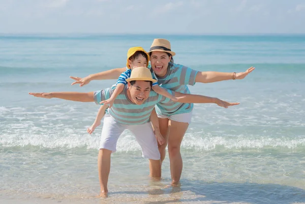 Gelukkig aziatisch gezin op het strand. Stockfoto